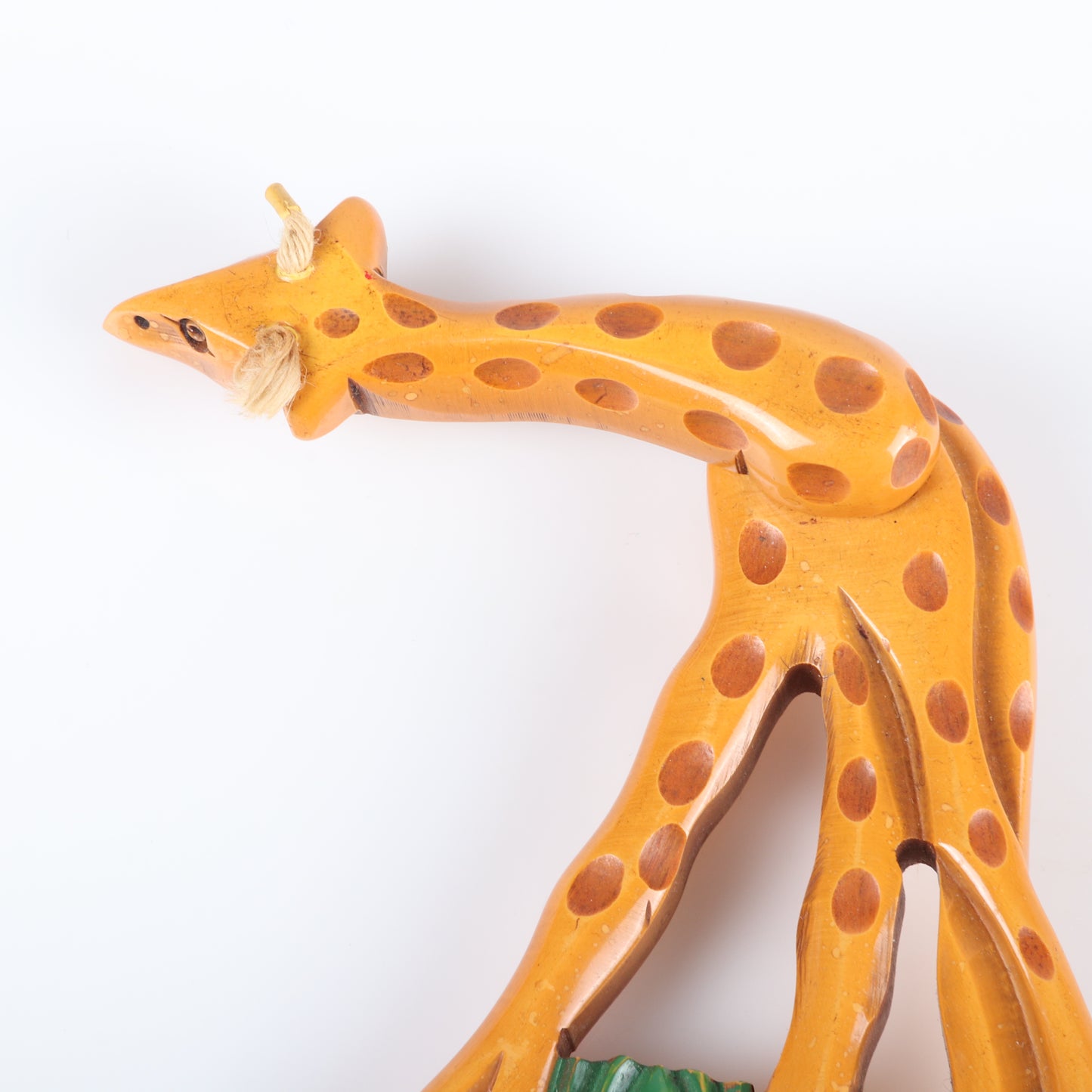 Vintage Bakelite carved figural articulated Giraffe pin brooch. Neck swivels 360 degrees. Painted grass. Wear to wax coating on strings. 4 12" H x 2 1/2"W