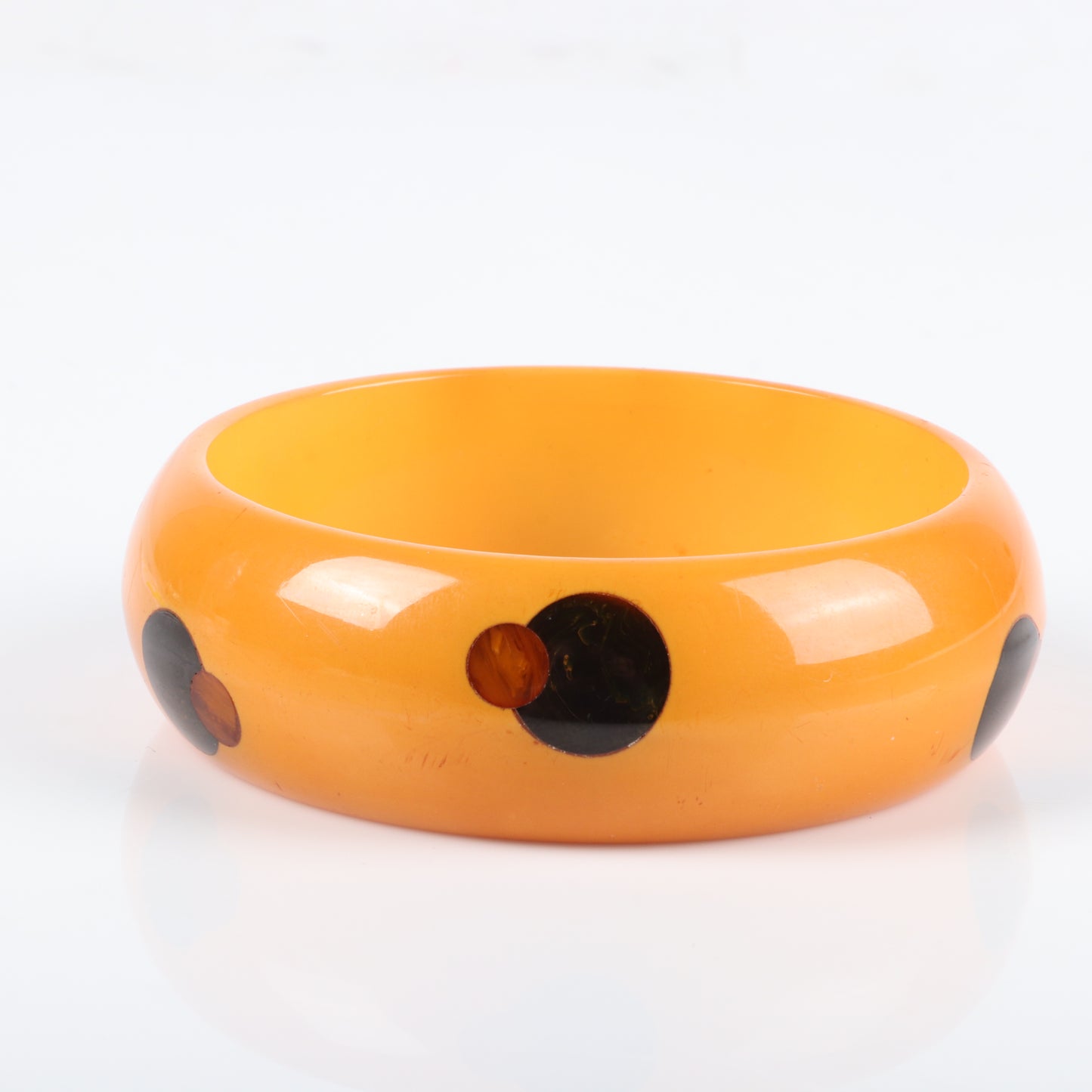 Vintage Bakelite overlapping dot pattern bangle bracelet. 2 1/2" inner diam, 1" W