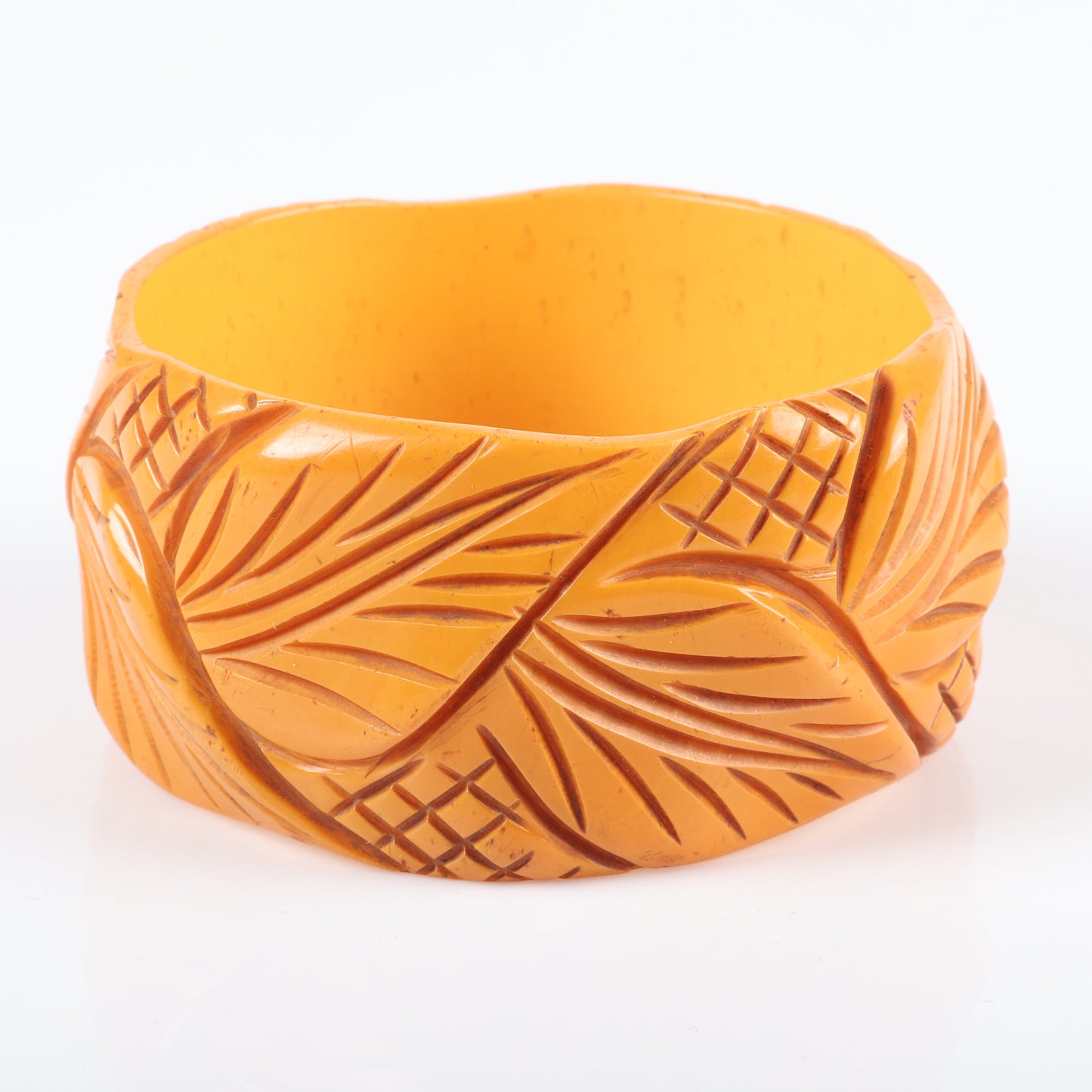 Vintage Bakelite set of 2 carved cuff bangle bracelets in butterscotch with leaf and modernist stepped machine age designs. 2 1/2" inner diam., 1.1/2" W