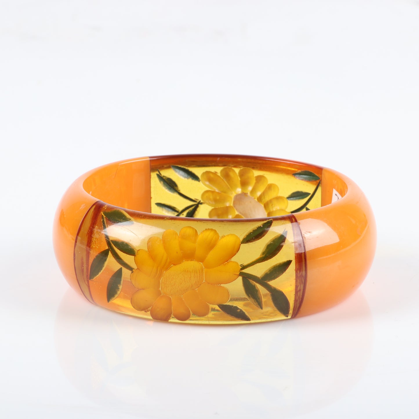 Vintage Bakelite chunky reverse carved and painted flower bangle bracelet with four laminated segments in butterscotch and apple juice. 2 1/2" inner diam., 1" W
