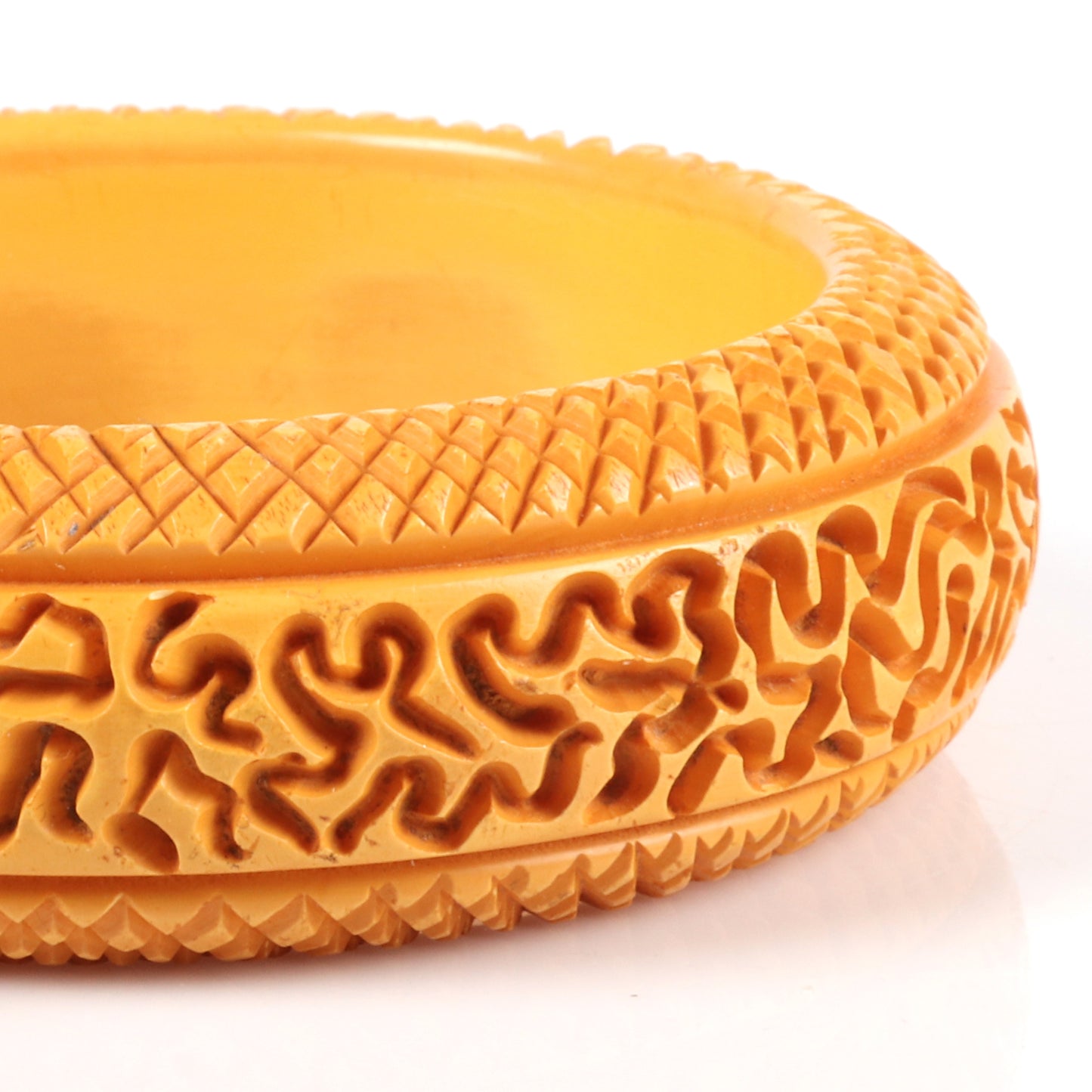 Vintage Bakelite carved butterscotch bangle bracelet with unusual random abstract pattern and cross hatch borders. 2 1/2" inner diam., 1" W