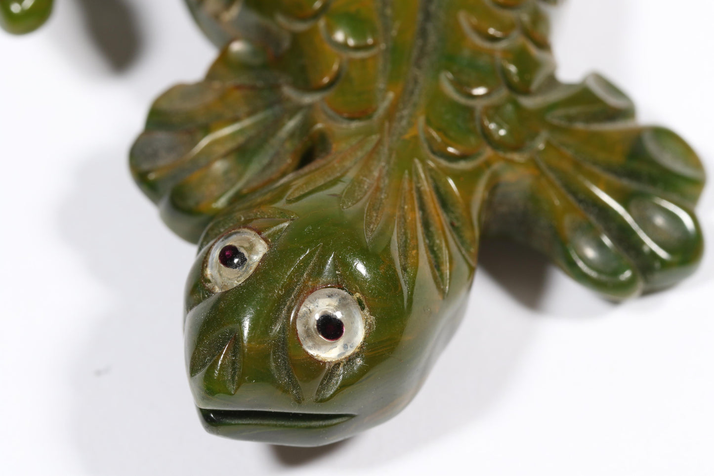 Vintage carved figural spinach Bakelite lizard brooch with glass eyes.