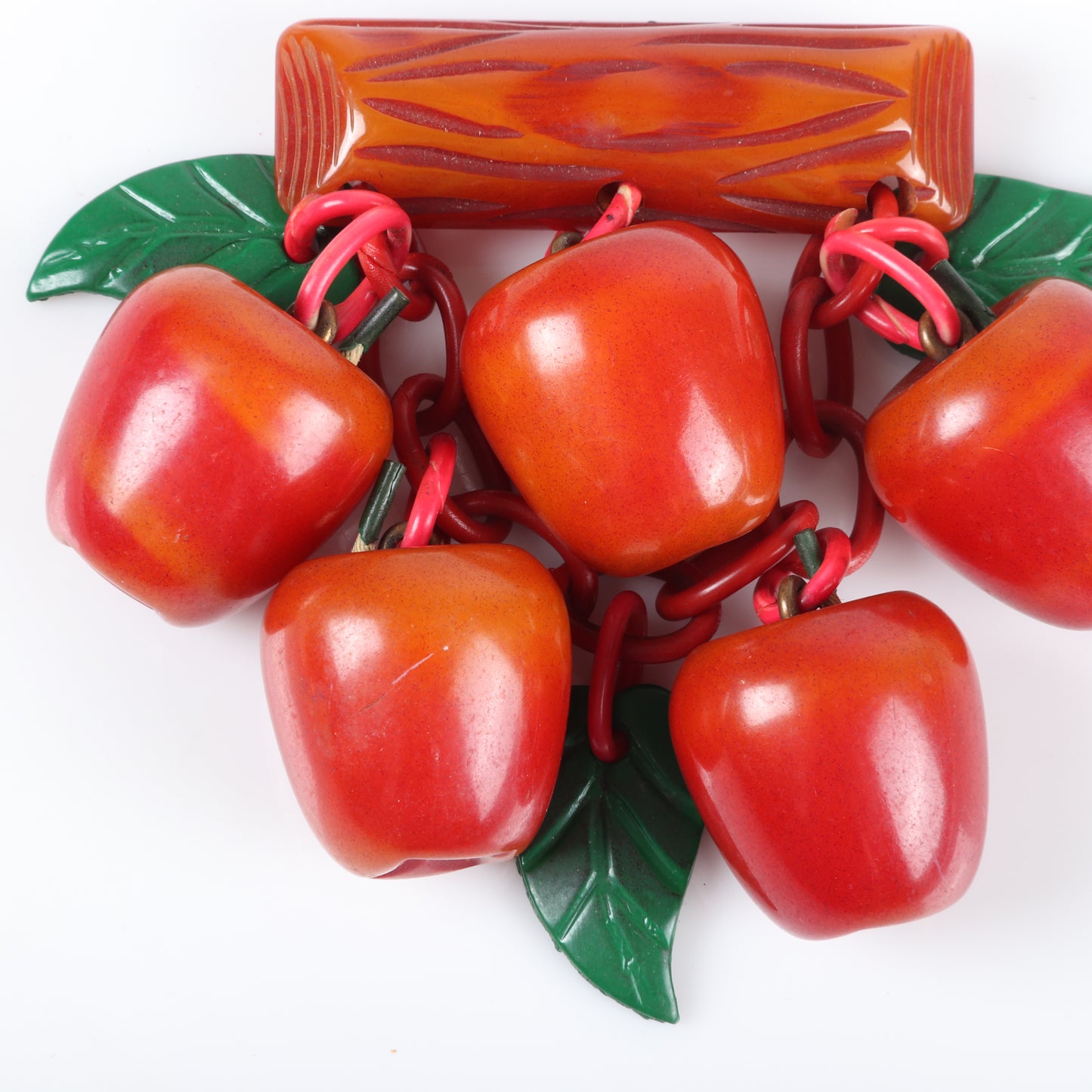 Vintage Bakelite fruit dangle brooch with over-dyed apple charms hanging from carved branch bar pin with celluloid chain and leaves. 3" H x 3 1/2" W