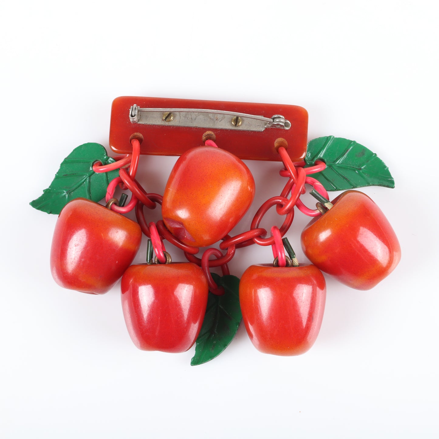 Vintage Bakelite fruit dangle brooch with over-dyed apple charms hanging from carved branch bar pin with celluloid chain and leaves. 3" H x 3 1/2" W