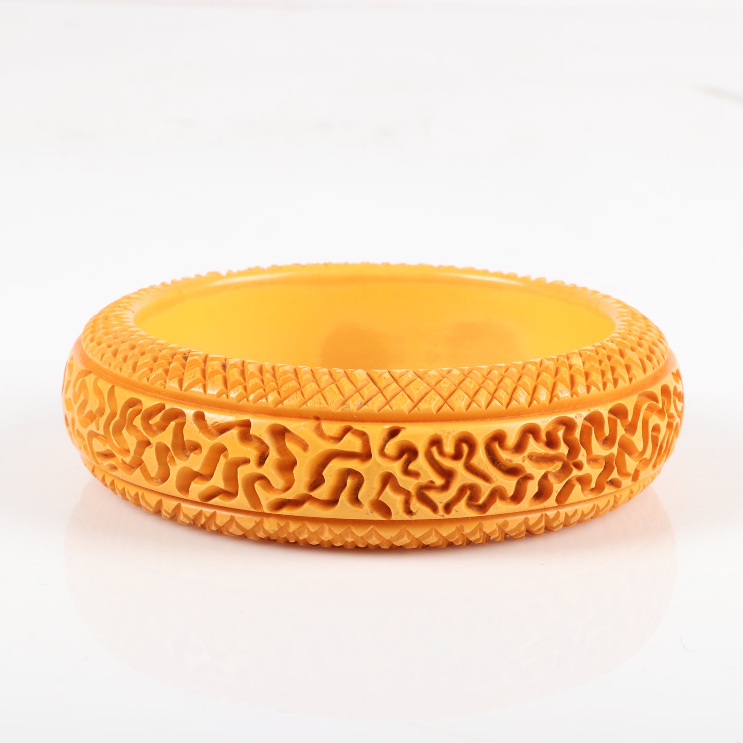 Vintage Bakelite carved butterscotch bangle bracelet with unusual random abstract pattern and cross hatch borders. 2 1/2" inner diam., 1" W