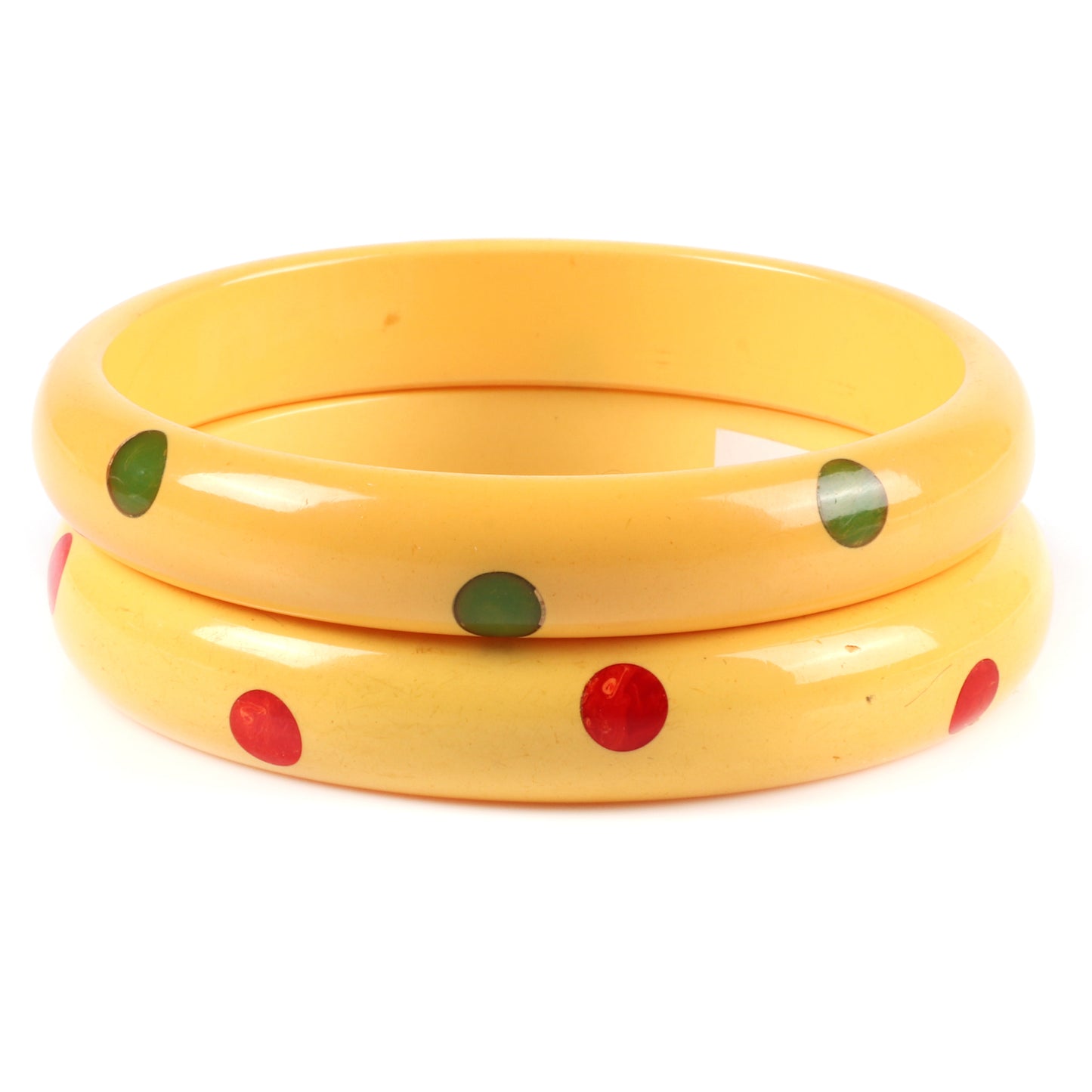 Vintage Bakelite 2pc. laminated dot bangle bracelets in cream corn each with 8 marbled red and green hi-low polka dots. 2 1/2" inner diam., 1/2" W