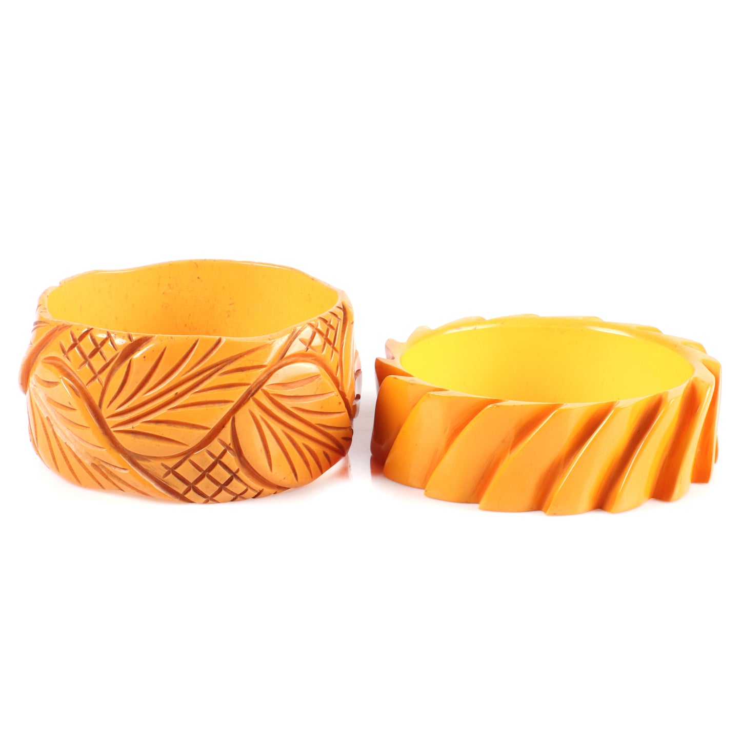Vintage Bakelite set of 2 carved cuff bangle bracelets in butterscotch with leaf and modernist stepped machine age designs. 2 1/2" inner diam., 1.1/2" W
