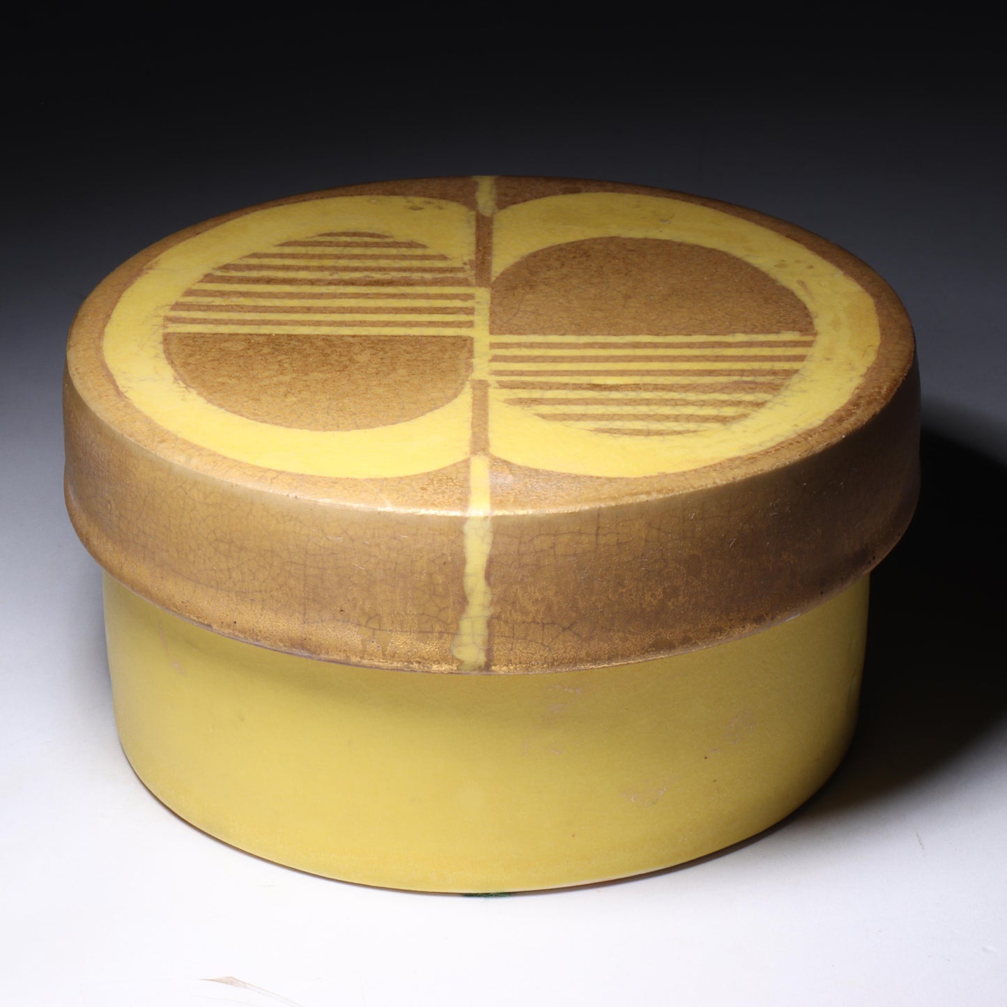 Laura Andreson, California (1902 - 1999), American studio pottery round covered porcelain box, 1975, porcelain, modernist painted design on lid in yellow and brown matte glazes, 3"H x 6"Diam.