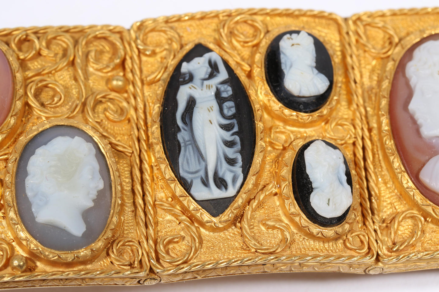 Antique 18K yellow gold Victorian panel bracelet with 19 intricate left and right facing cameos carved from natural stone including tigers eye, onyx, coral, shell, and more. 8 1/4"L x 1 1/8"W