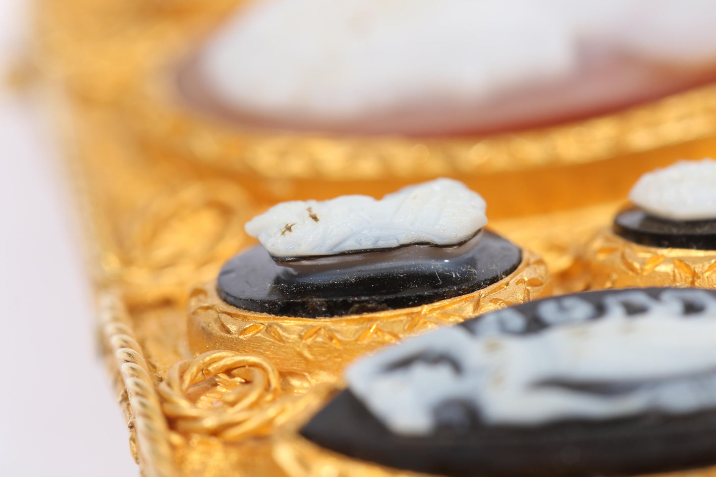 Antique 18K yellow gold Victorian panel bracelet with 19 intricate left and right facing cameos carved from natural stone including tigers eye, onyx, coral, shell, and more. 8 1/4"L x 1 1/8"W