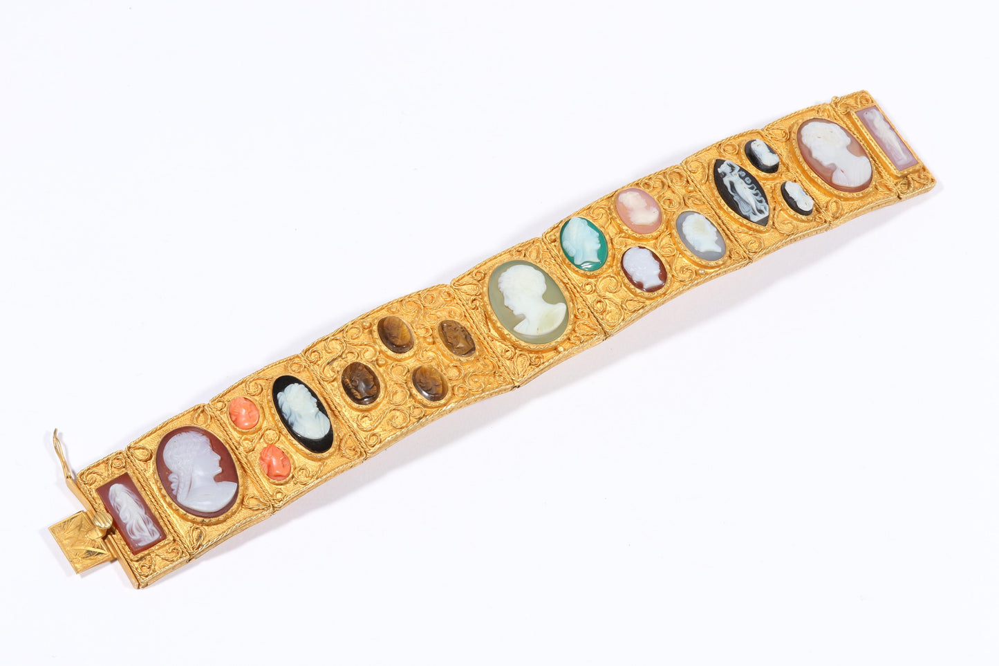 Antique 18K yellow gold Victorian panel bracelet with 19 intricate left and right facing cameos carved from natural stone including tigers eye, onyx, coral, shell, and more. 8 1/4"L x 1 1/8"W