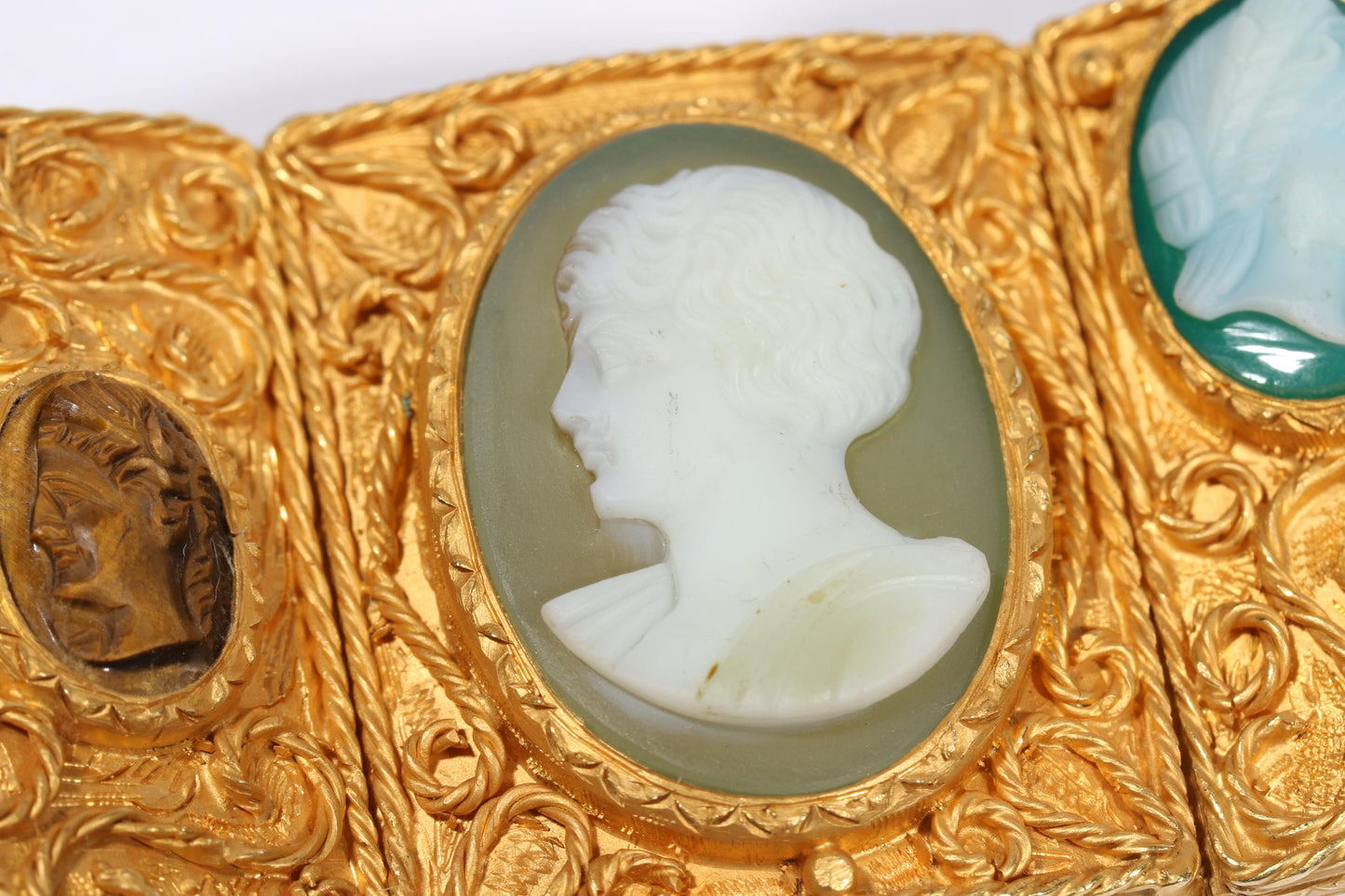 Antique 18K yellow gold Victorian panel bracelet with 19 intricate left and right facing cameos carved from natural stone including tigers eye, onyx, coral, shell, and more. 8 1/4"L x 1 1/8"W