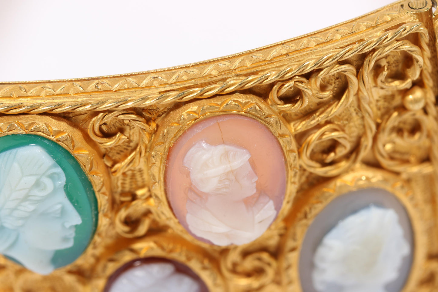 Antique 18K yellow gold Victorian panel bracelet with 19 intricate left and right facing cameos carved from natural stone including tigers eye, onyx, coral, shell, and more. 8 1/4"L x 1 1/8"W