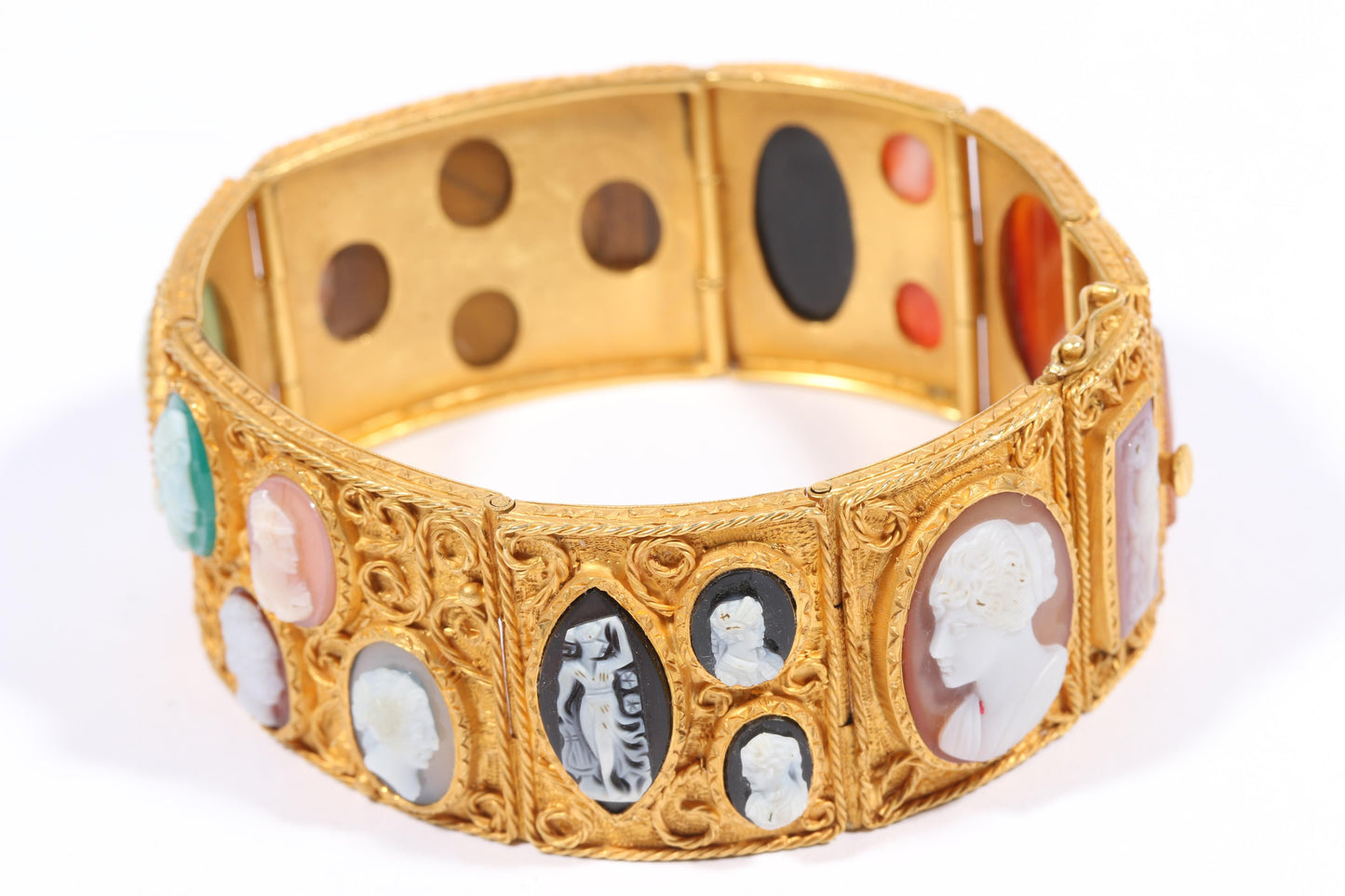 Antique 18K yellow gold Victorian panel bracelet with 19 intricate left and right facing cameos carved from natural stone including tigers eye, onyx, coral, shell, and more. 8 1/4"L x 1 1/8"W