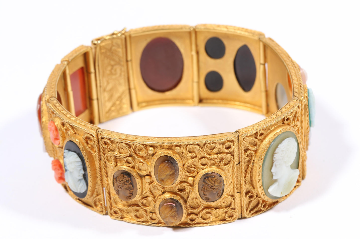 Antique 18K yellow gold Victorian panel bracelet with 19 intricate left and right facing cameos carved from natural stone including tigers eye, onyx, coral, shell, and more. 8 1/4"L x 1 1/8"W